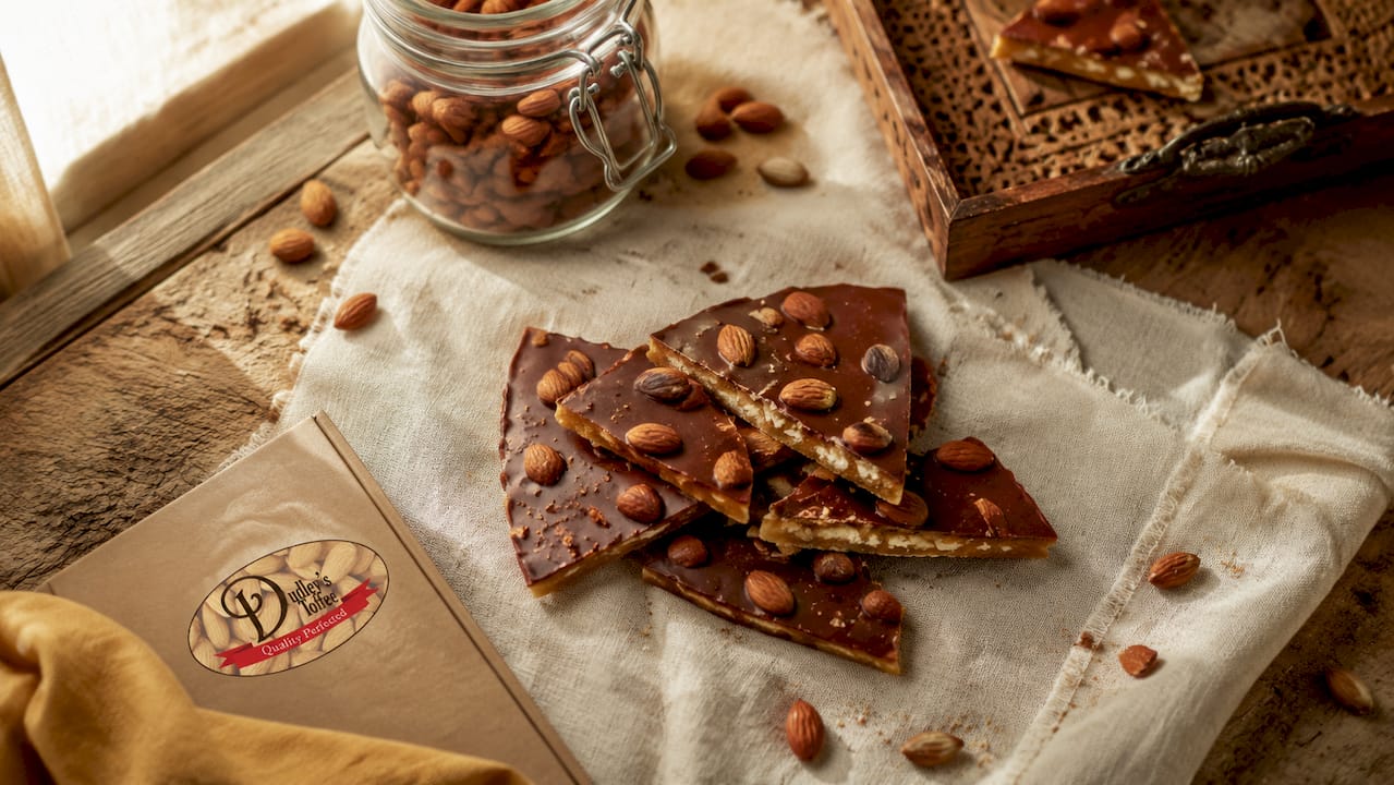 Handcrafted gluten free English almond toffee on rustic wood