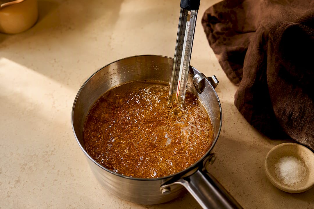 Amber syrup reaching hard crack with thermometer